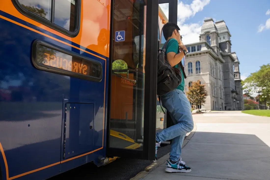 A person exiting a Syracuse University shuttle.